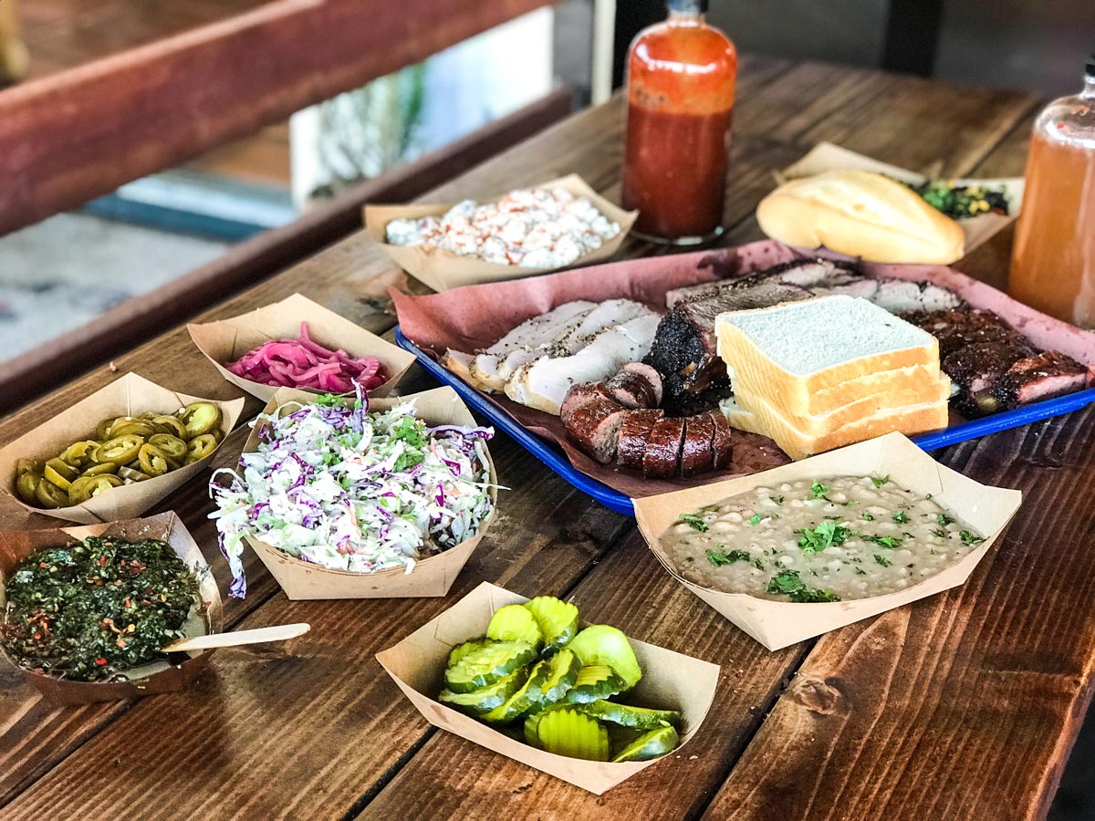 Barbecue plate with smoked meats, baked beans, and coleslaw.