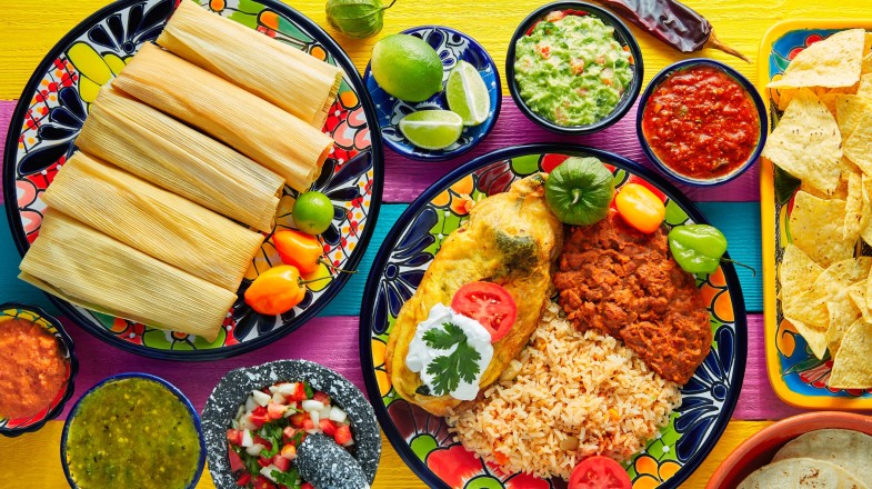 Colorful platter of Mexican food with tacos, rice, and vegetables.